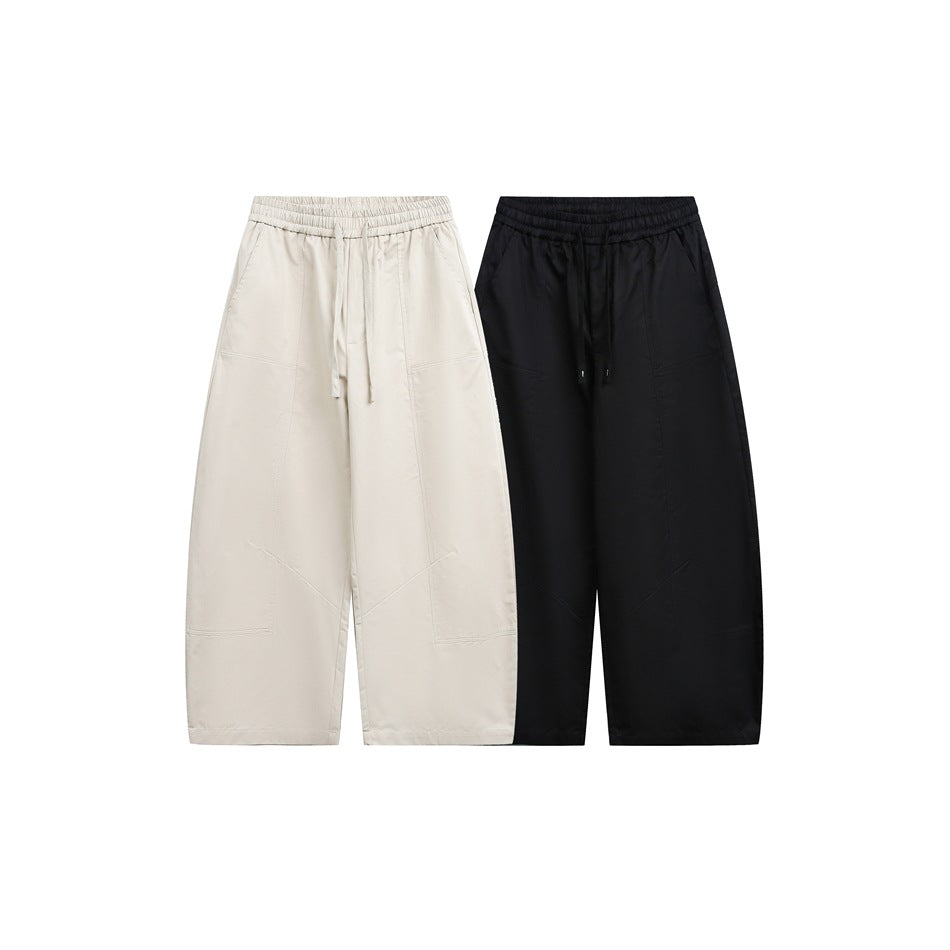 Front view of loose, wide-leg drawstring pants in beige and black, shown side by side on a white background.