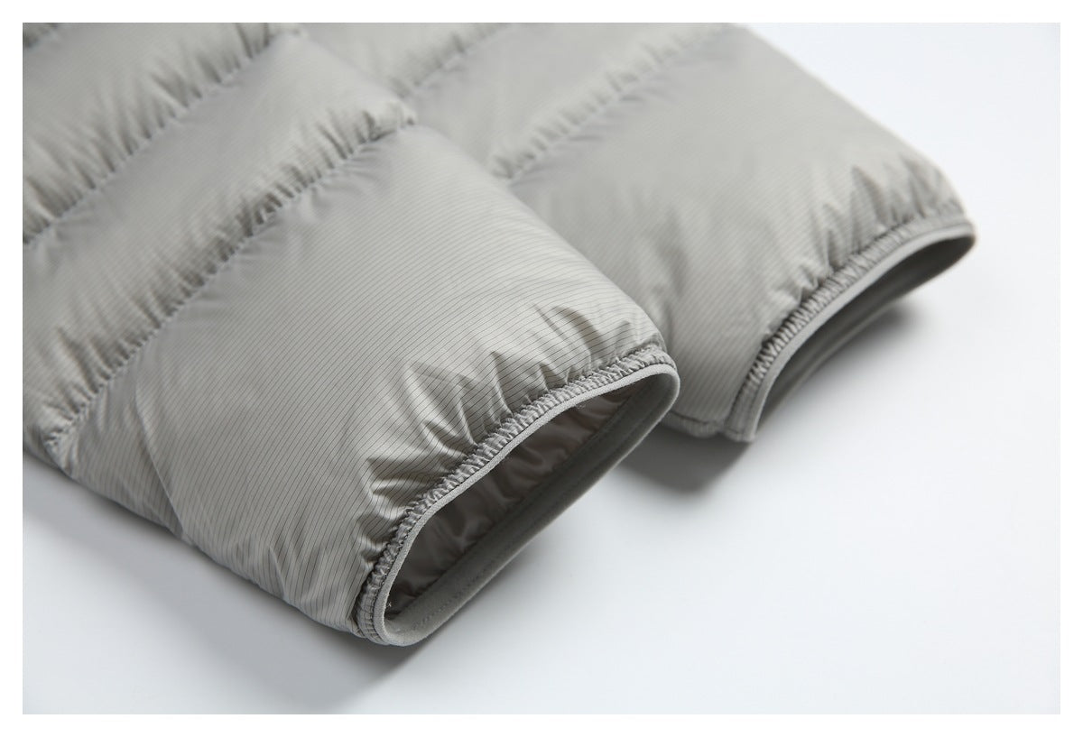 Close-up of the quilted sleeve cuffs and gathered binding on a light gray pinstriped jacket.