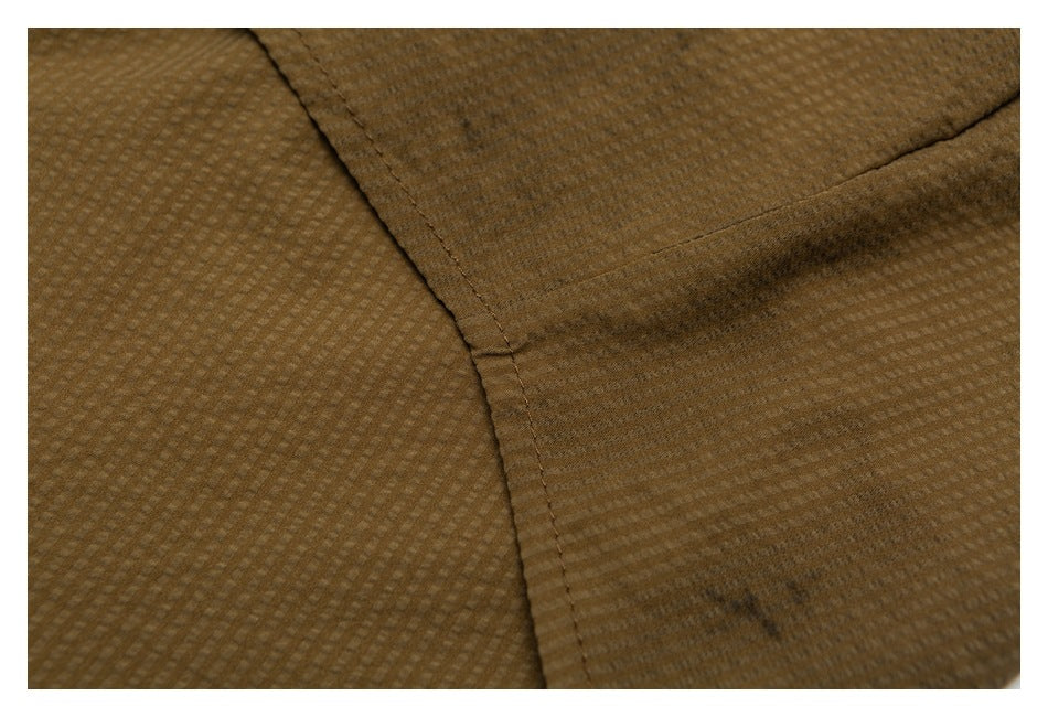 Close-up of a stitched seam joining panels of brown fabric with a subtle woven check texture.