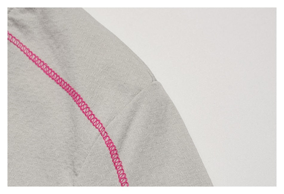 Close-up of the light gray sleeve showing a curved seam with bright pink overlock stitching.
