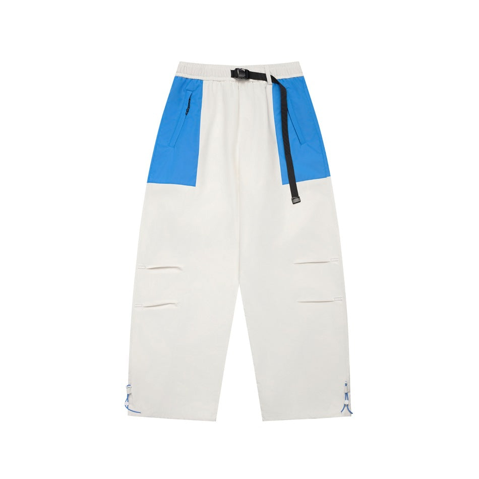 White wide-leg pants with blue hip panels, black buckle belt, thigh pleats and drawcord hems, flat front view