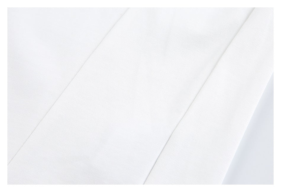 Close-up of smooth white garment fabric with diagonal panel seams.