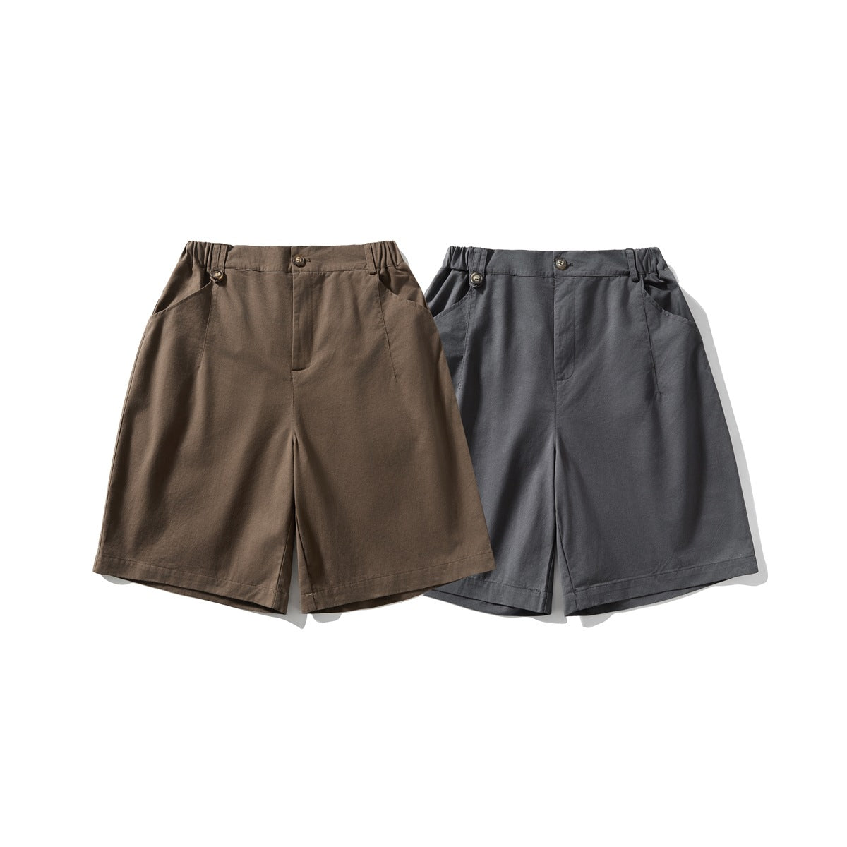 Front view of two pairs of wide-leg shorts, one brown and one charcoal gray, with button closures and angled pockets.