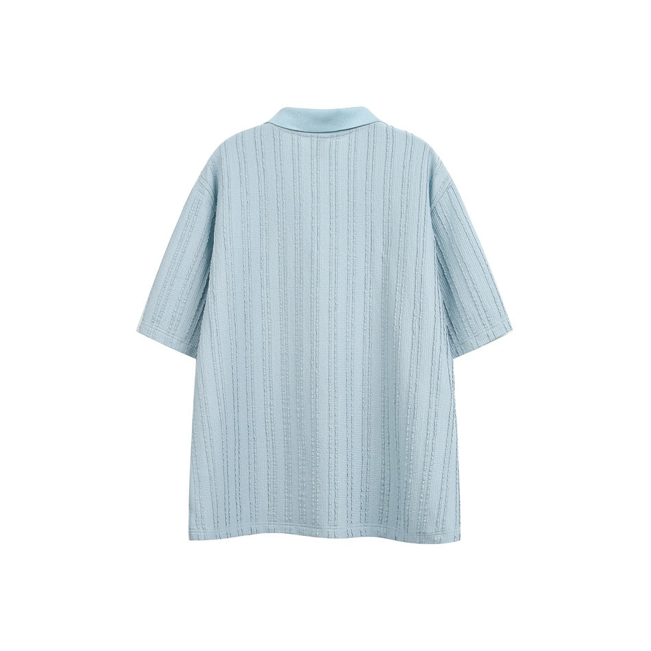 Back view of a pale blue short-sleeve polo shirt with vertical textured stripes.