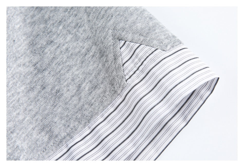 Close-up of a white cuff with fine dark stripes on a gray sleeve.