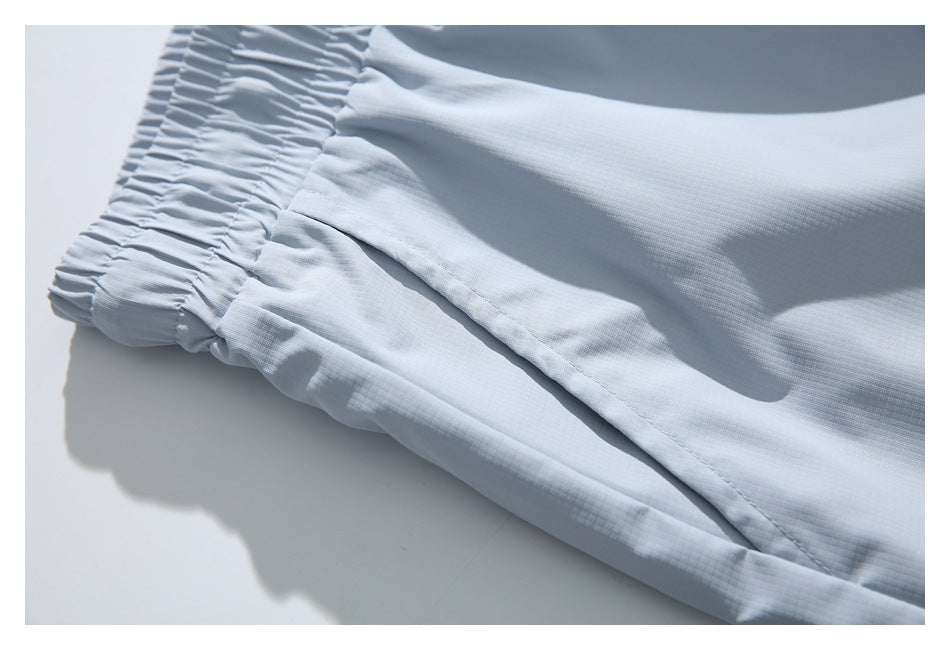 Close-up of pale blue-gray shorts showing the gathered waistband and a slanted side pocket.