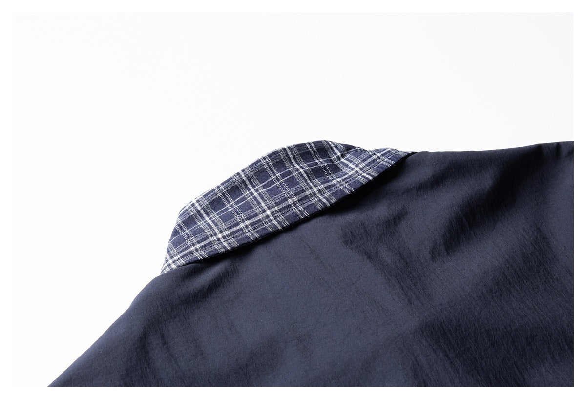 Close-up of a dark navy garment with a navy-and-white plaid collar lining.