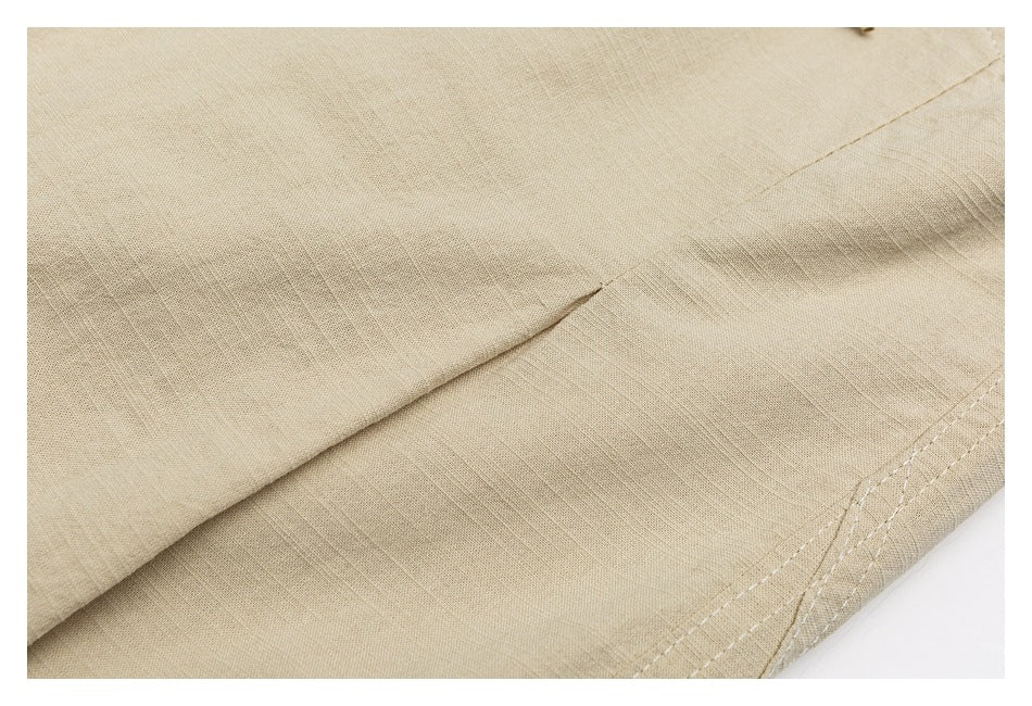 Close-up of beige fabric with a folded seam and double stitching along the edge.