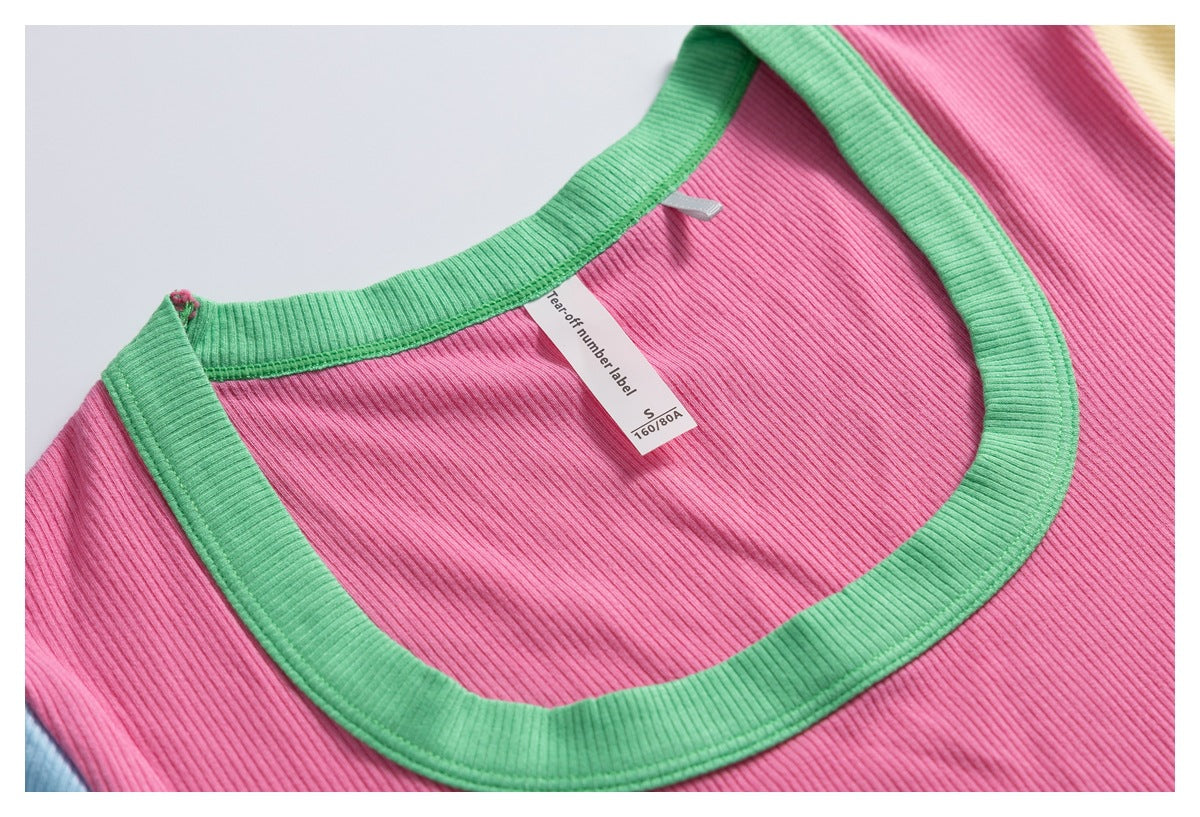 Close-up of a pink ribbed shirt neckline with green trim and a small size label.