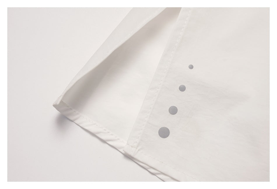Close-up of a white skirt seam and hem, with four small gray circles arranged vertically on the fabric.