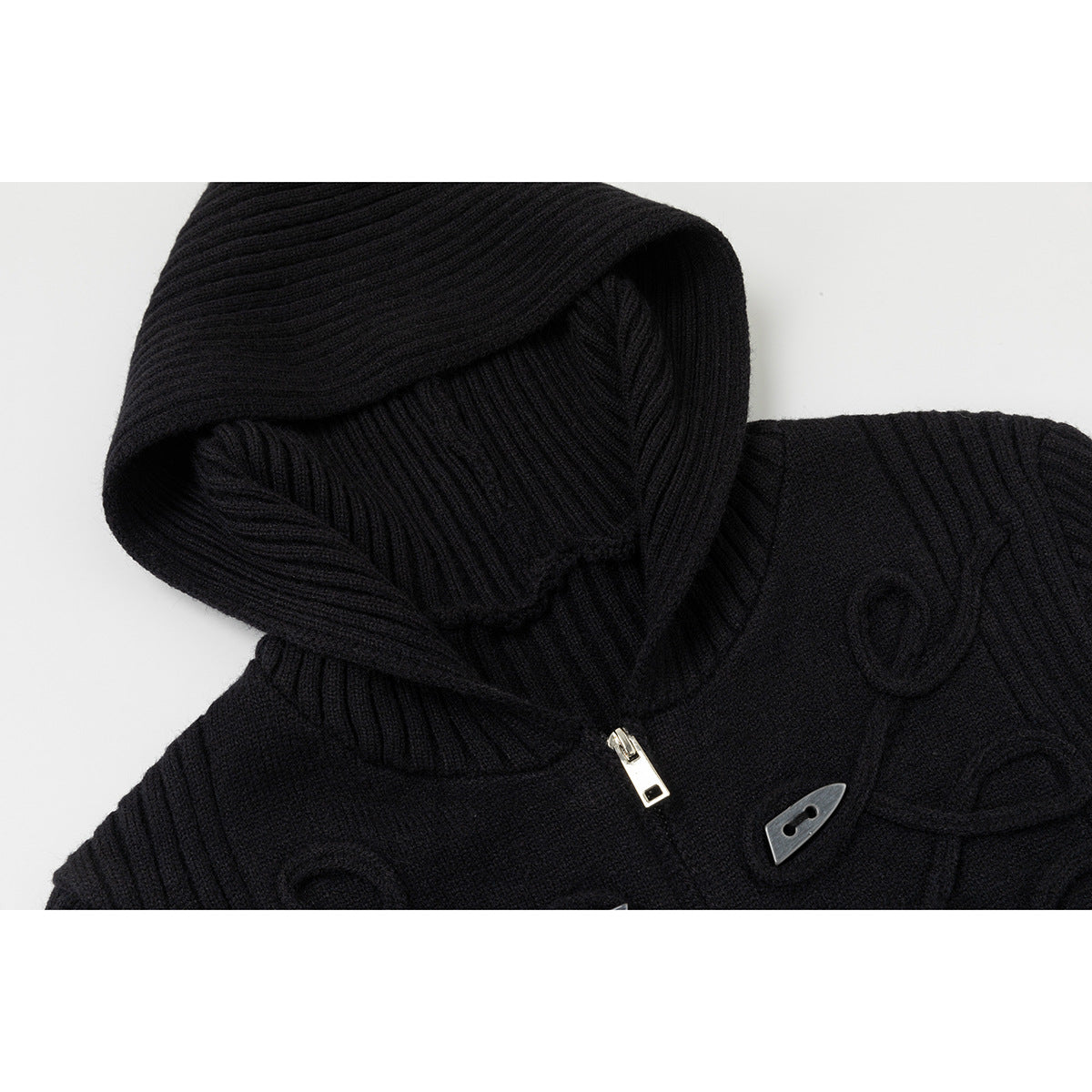 Close-up of a black rib-knit hood and toggle detail on a zip-front cardigan.