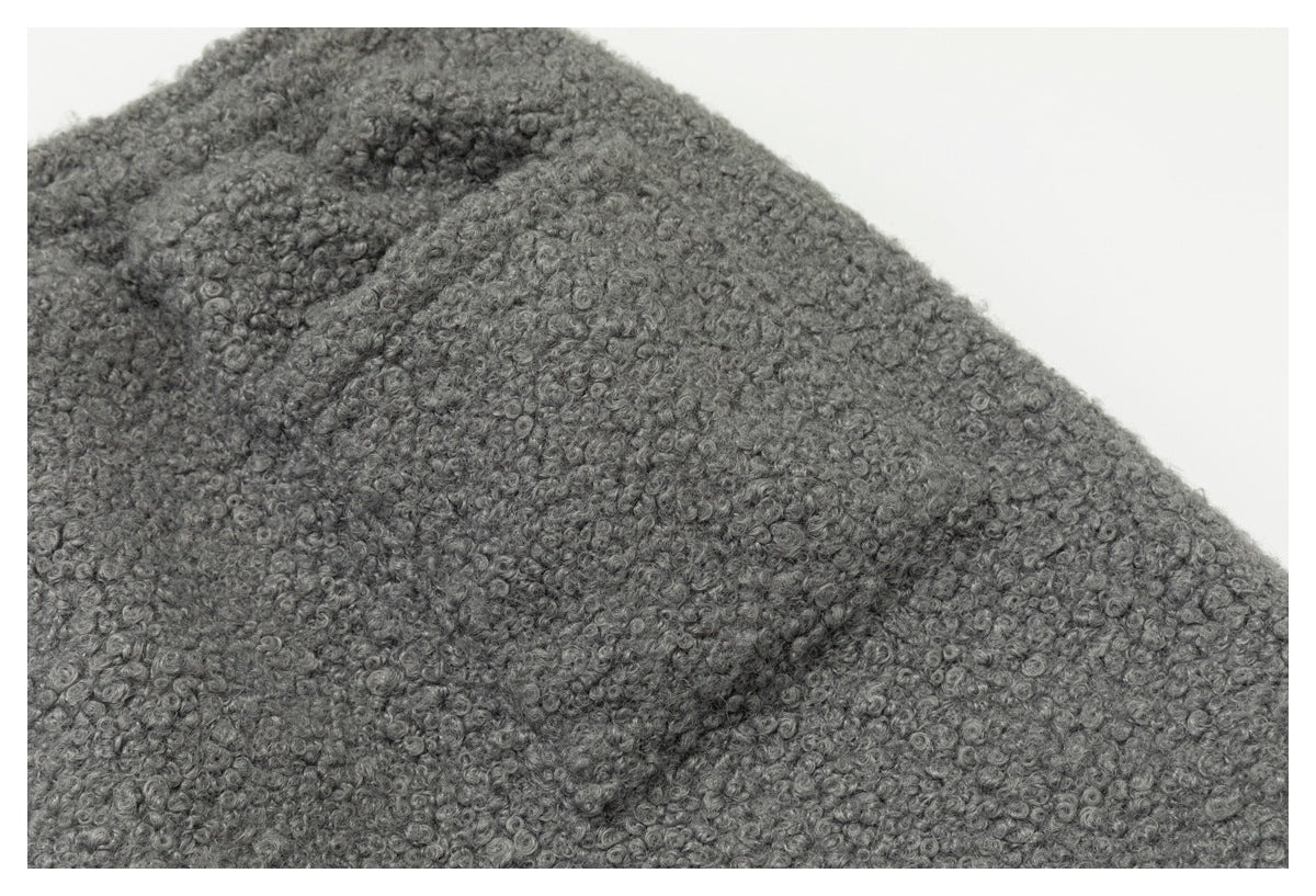 Close-up of dense, curly gray fabric with a looped texture.