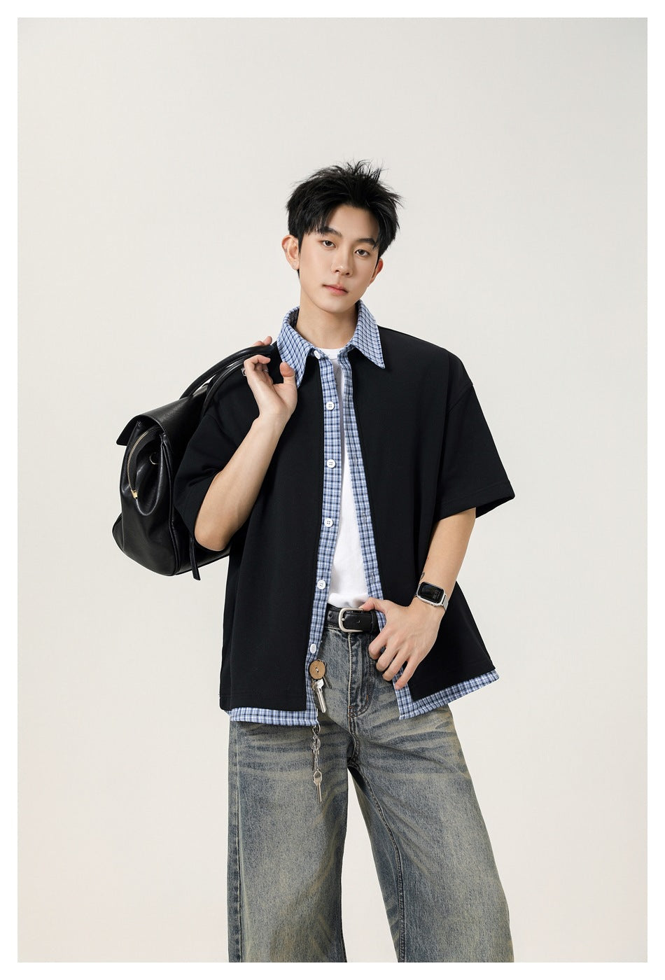 Model wearing a black short-sleeve shirt with blue plaid collar, button placket and hem trim.
