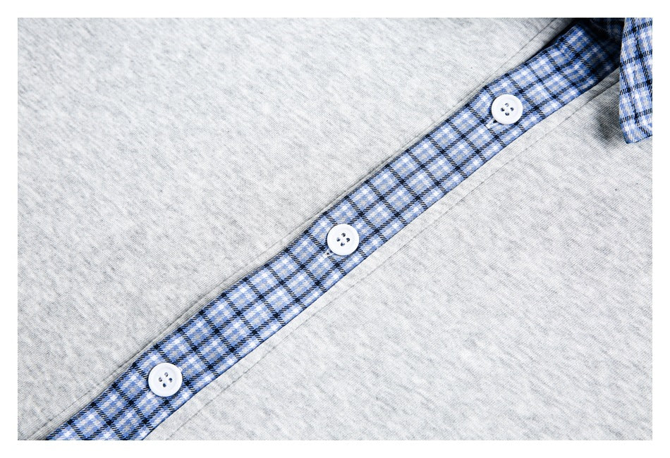 Close-up of a gray top's blue plaid button placket with three white buttons.