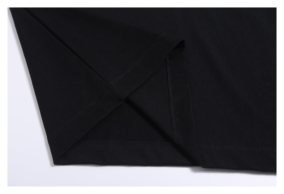 Close-up of the black T-shirt’s hem and stitching against a white background.