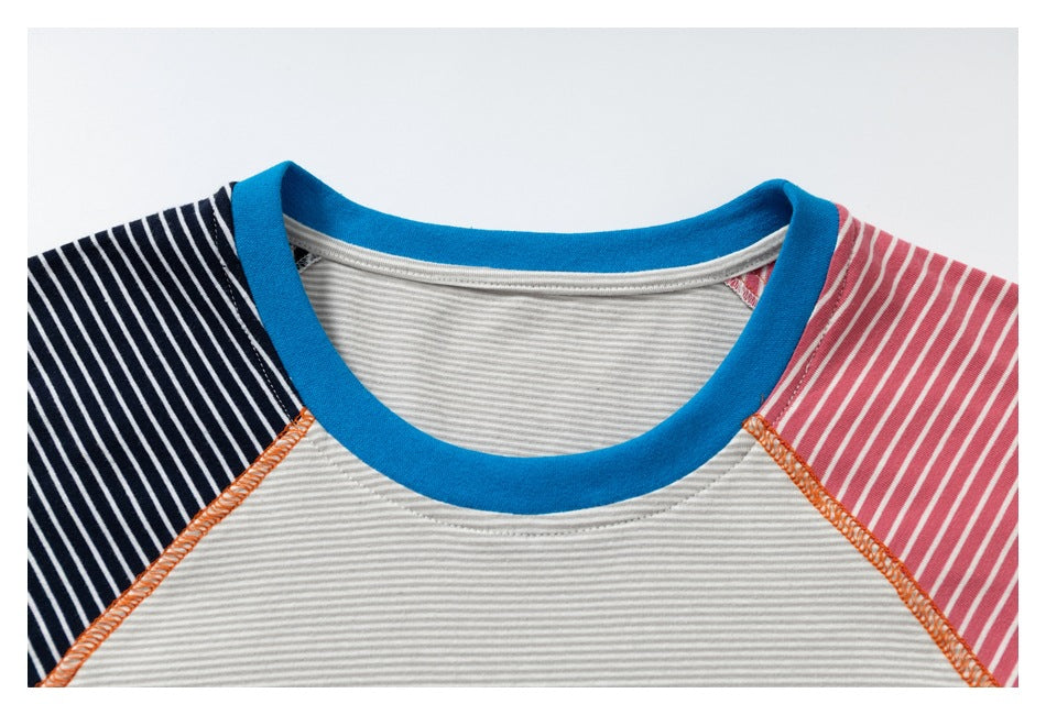 Close-up of a blue-bound neckline, gray-and-white striped body, and navy and pink striped raglan sleeves.