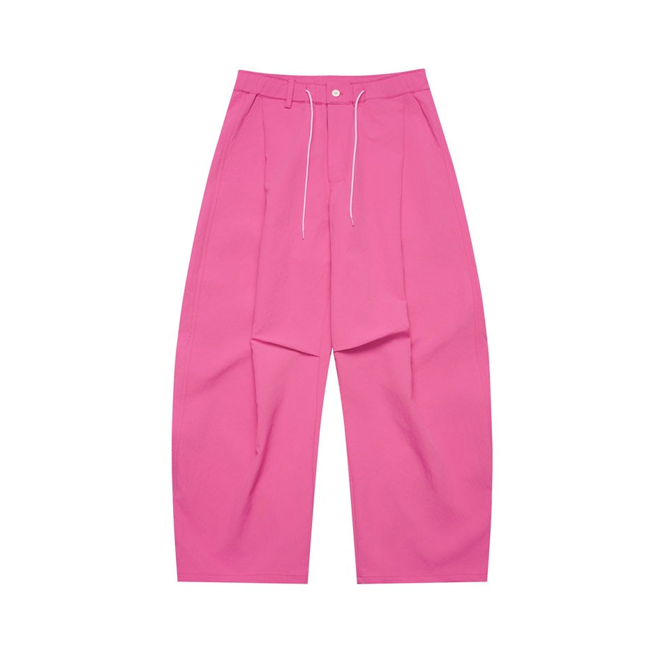 Hot pink wide-leg pleated pants with drawstring waist and button front, flat lay