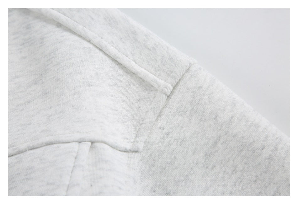 Close-up of the light gray marled jacket shoulder seam and sleeve.