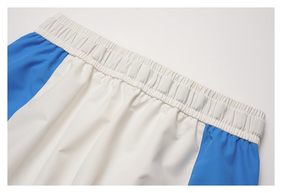 Close-up of white elastic waistband and blue side panels on white pants.