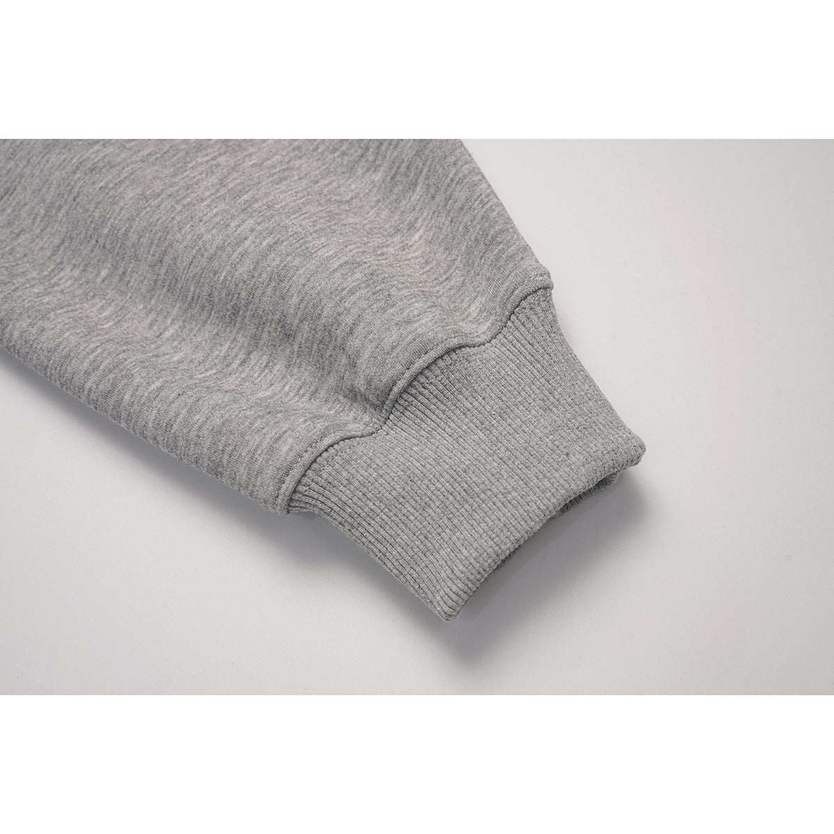 Close-up of a light gray sleeve ending in a ribbed cuff.