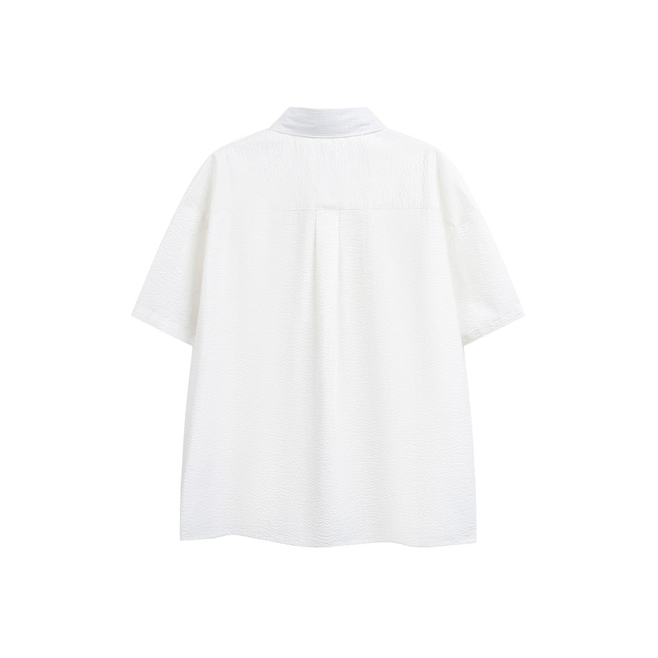 Back view of a white short-sleeve button-up shirt with a collar and center back pleat.