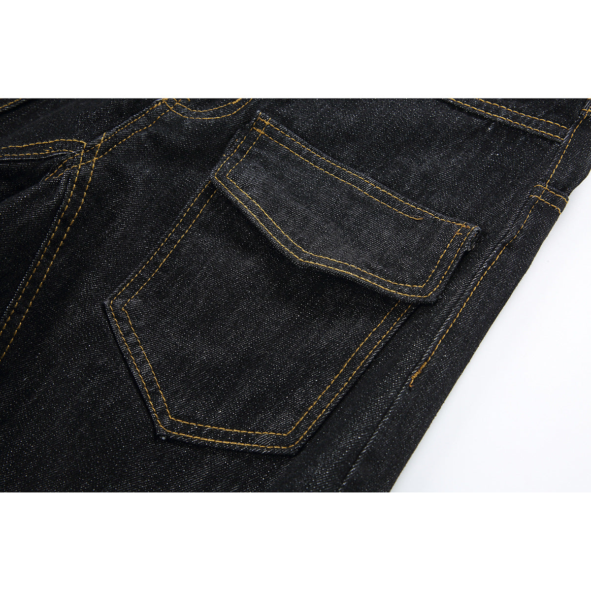 Close-up of a rear patch pocket on black denim jeans with contrasting golden stitching.
