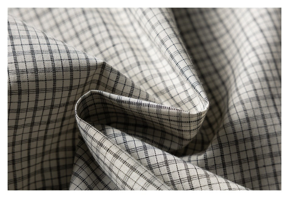 Close-up of draped cream fabric with a fine black windowpane check.