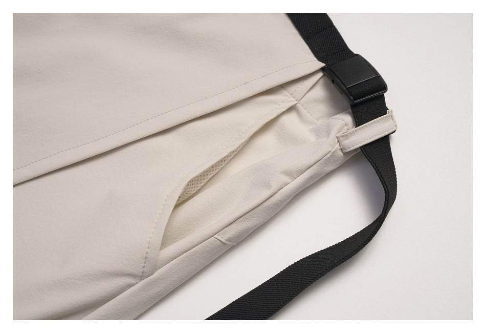 Close-up of the beige wrap skirt's overlapping panels, inner lining, and black adjustable waist strap.
