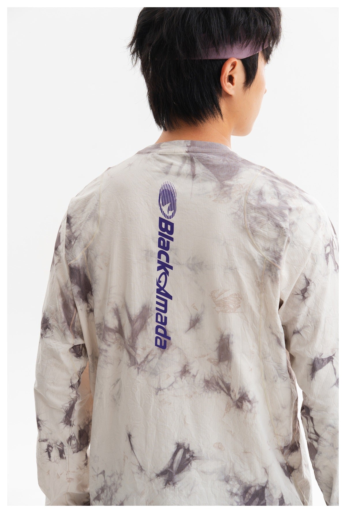 Close back view of a cream and gray tie-dye long-sleeve shirt with a vertical purple logo.