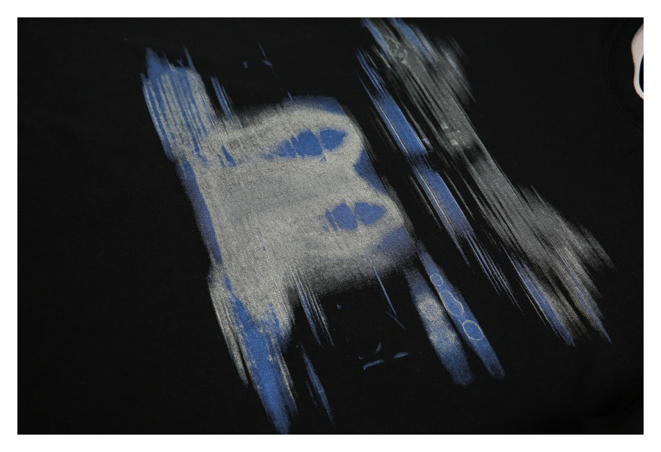 Close-up of the T-shirt's abstract blue and gray graphic printed on black fabric.