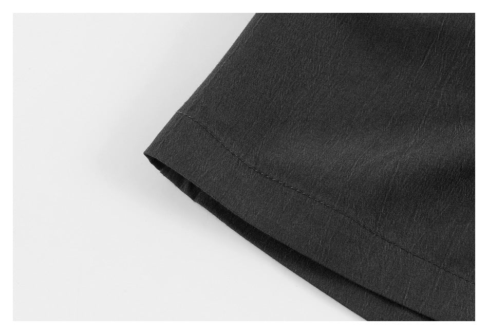 Close-up of the stitched hem on a black trouser leg.