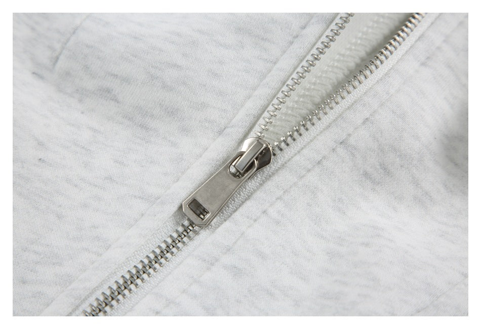 Close-up of the silver zipper and pull on the light gray marled jacket.