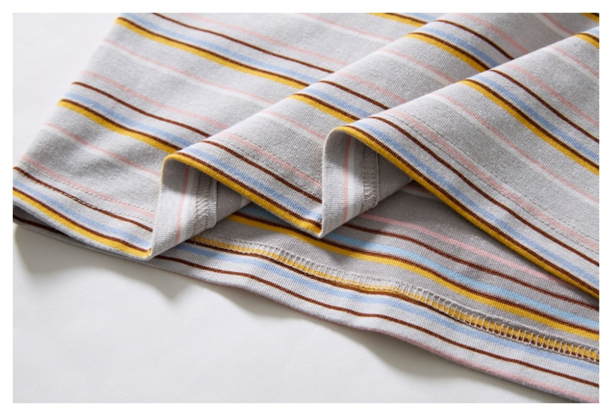 Close-up of a folded striped garment edge showing the underside and overlocked hem stitching.