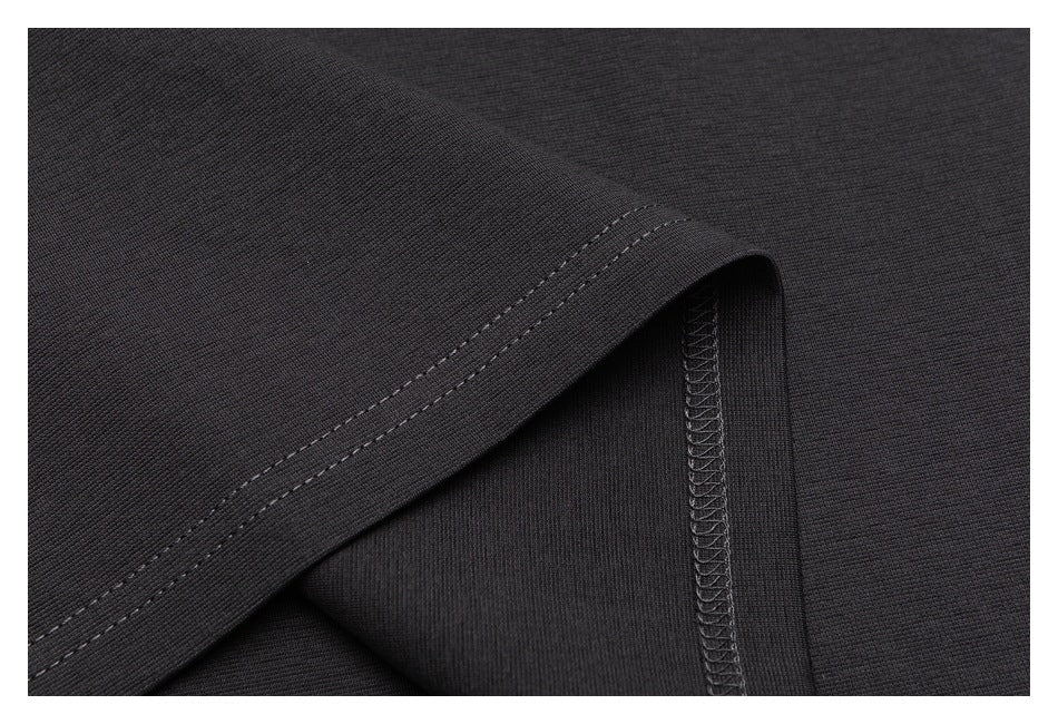 Close-up of a dark garment hem showing double stitching and an overlocked seam.