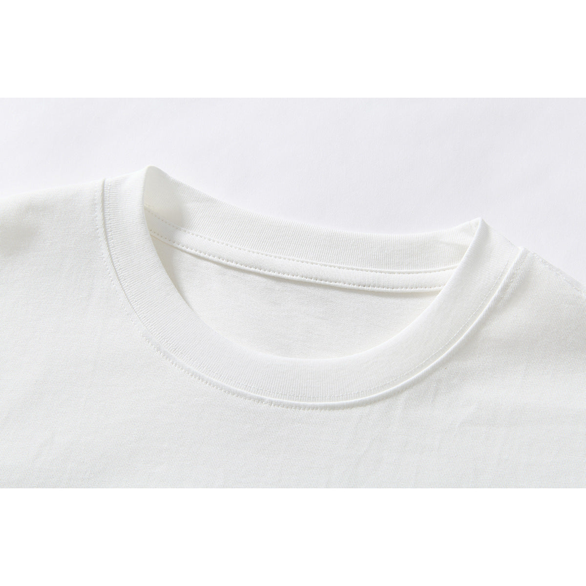 Close-up of the white T-shirt's ribbed crew neckline and collar stitching.