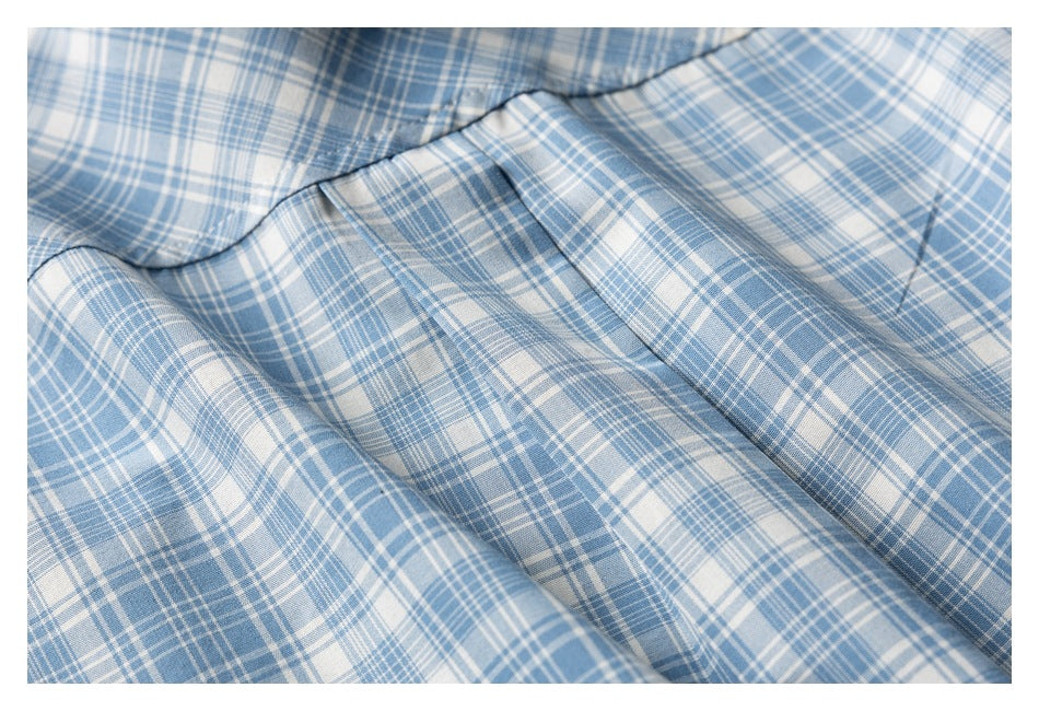 Close-up of blue and white plaid fabric arranged in soft folds.