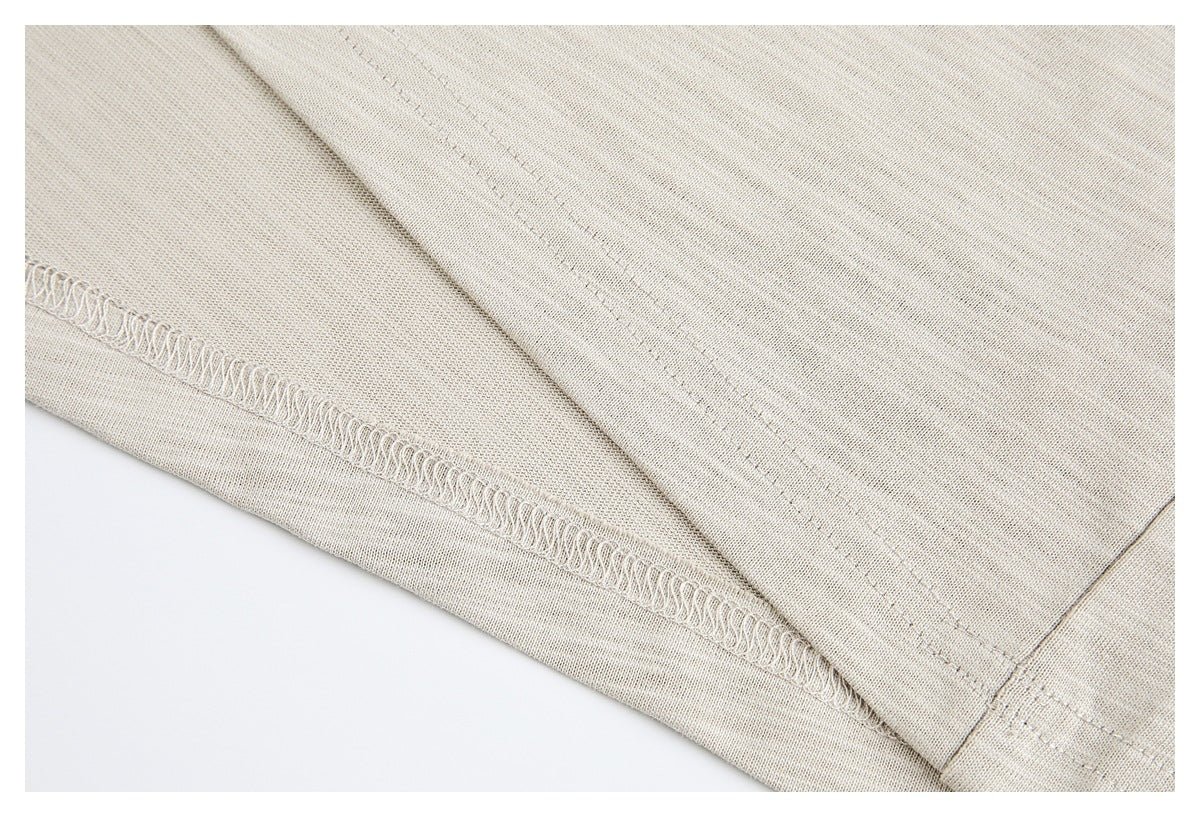 Close-up of beige garment fabric showing an overlocked seam and parallel stitching.