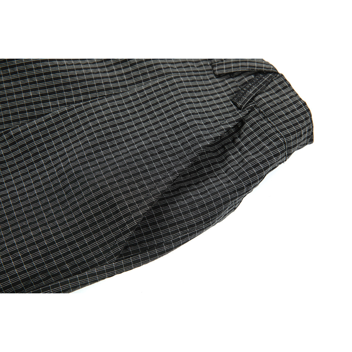 Close-up of a slanted pocket on dark charcoal shorts with a fine gray plaid pattern.