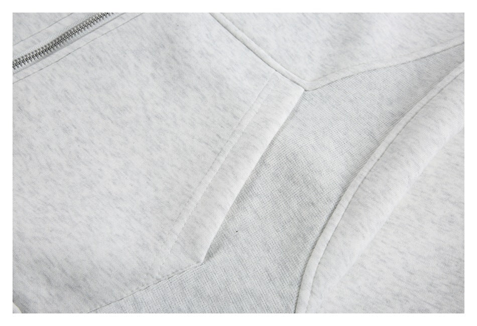Close-up of light gray heather garment panel seams with a section of metal zipper.