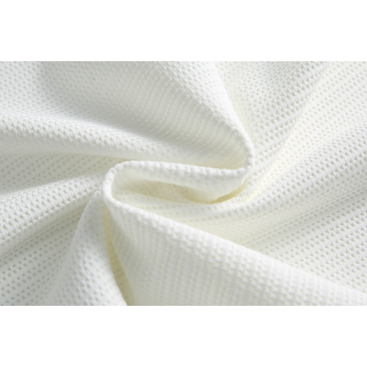 Close-up of softly folded white textured knit fabric.