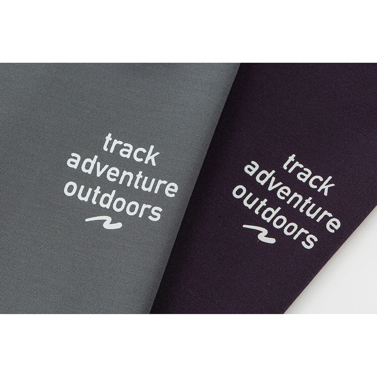 Close-up of the white “track adventure outdoors” chest print on gray and plum shirts.