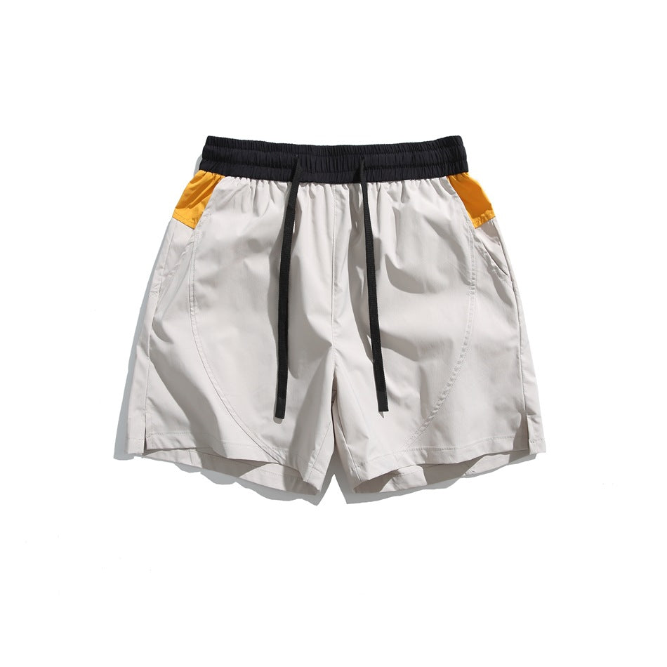 Light gray drawstring shorts with black waistband and orange-yellow side panels, flat lay front view