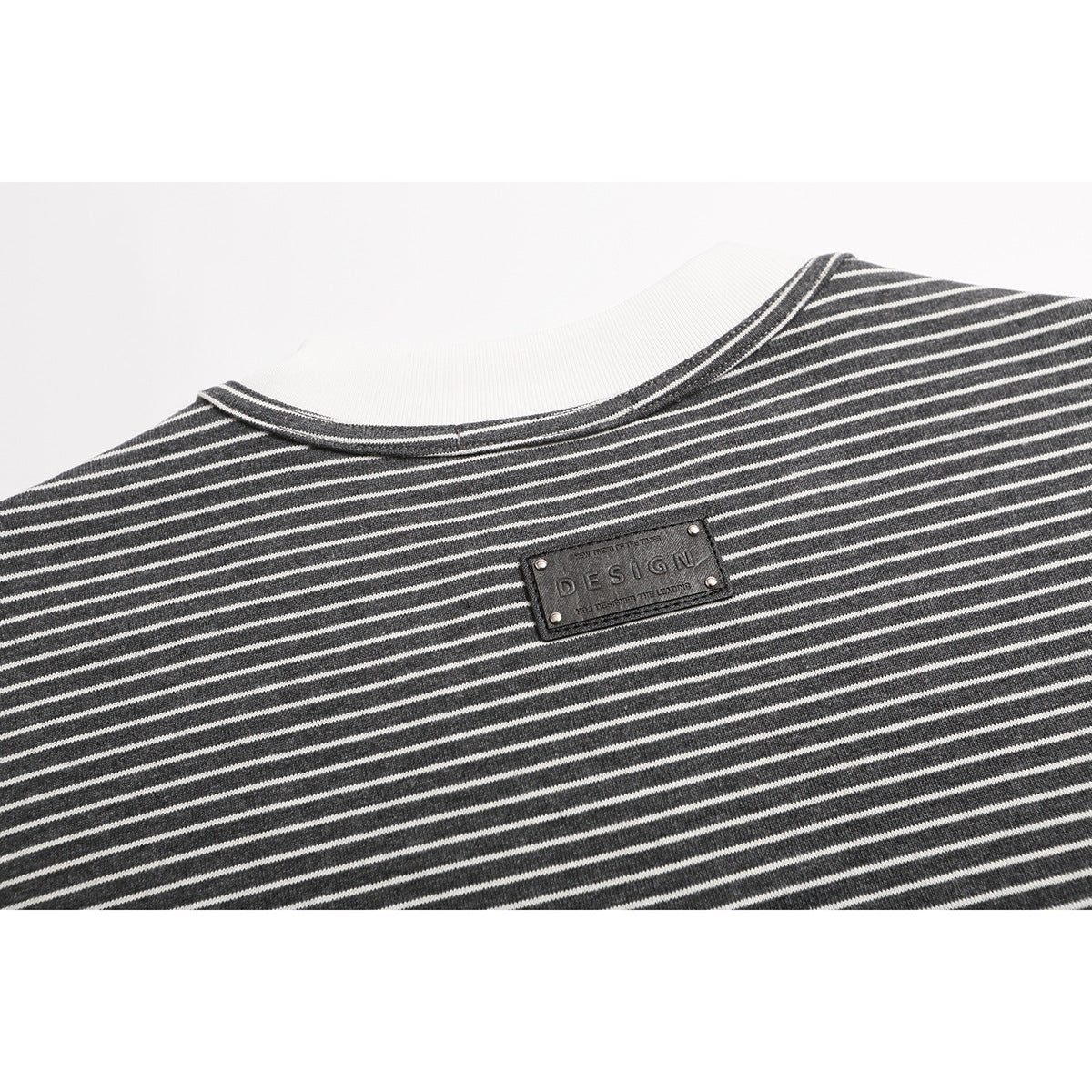 Close-up of the striped T-shirt's back neckline and small dark rectangular patch.