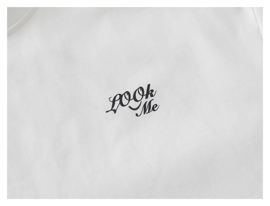 Close-up of black script artwork printed on white T-shirt fabric.
