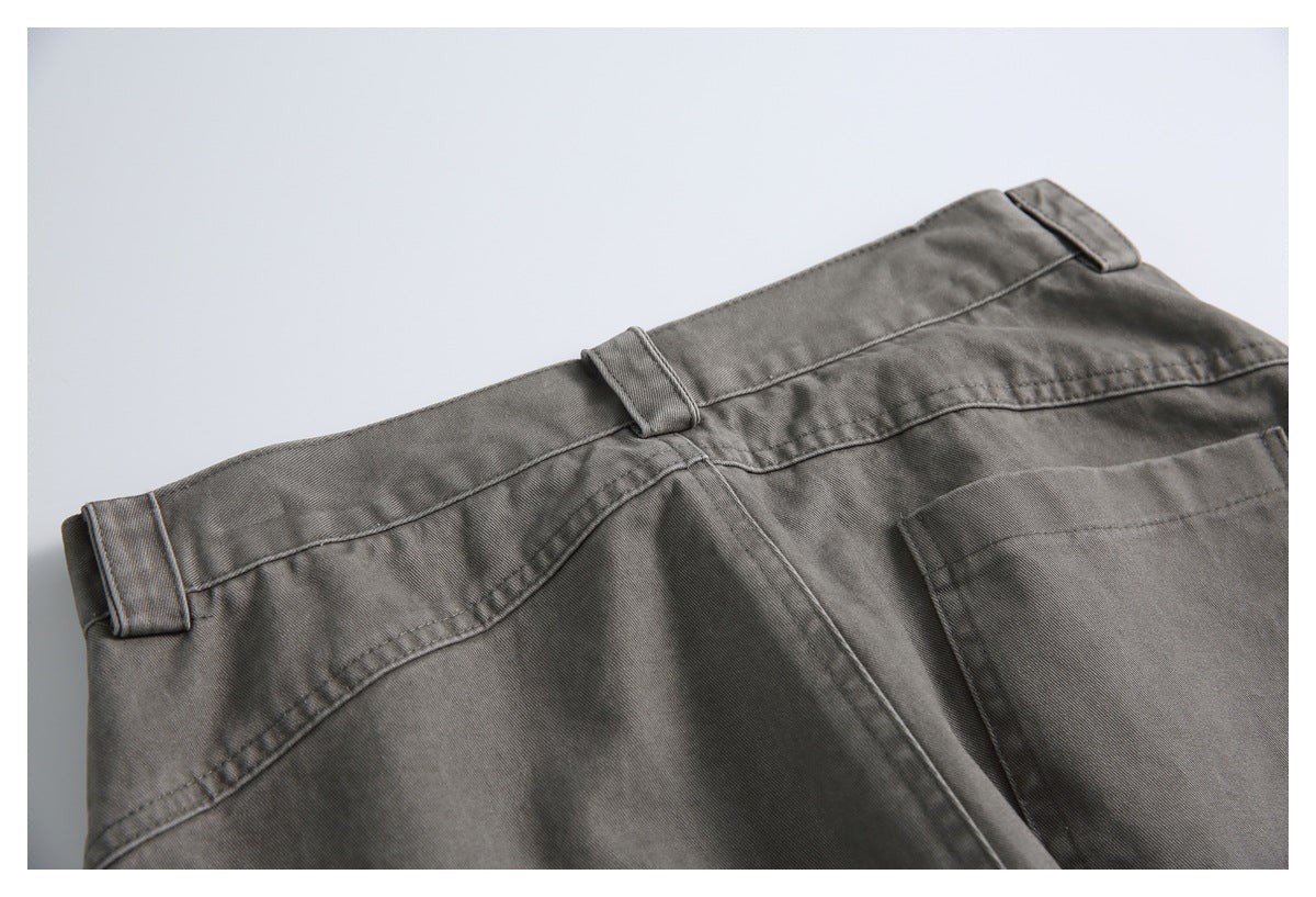 Close-up of the back waistband of charcoal-gray trousers, with belt loops, a yoke seam, and a rear pocket.