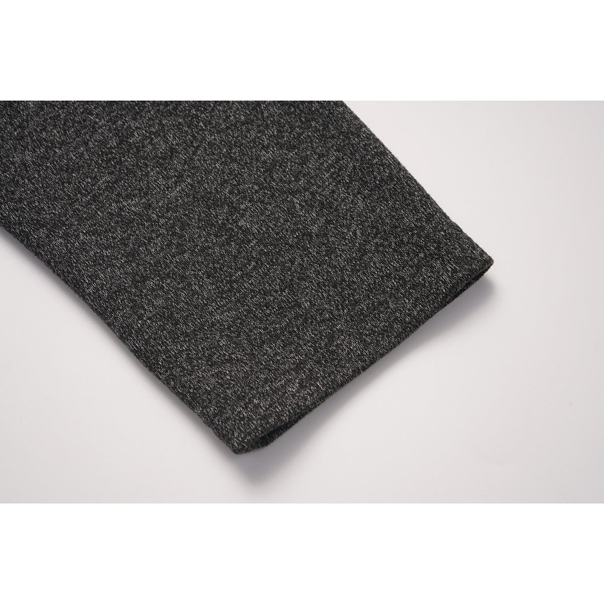 Close-up of the charcoal marled sleeve and its straight hem.