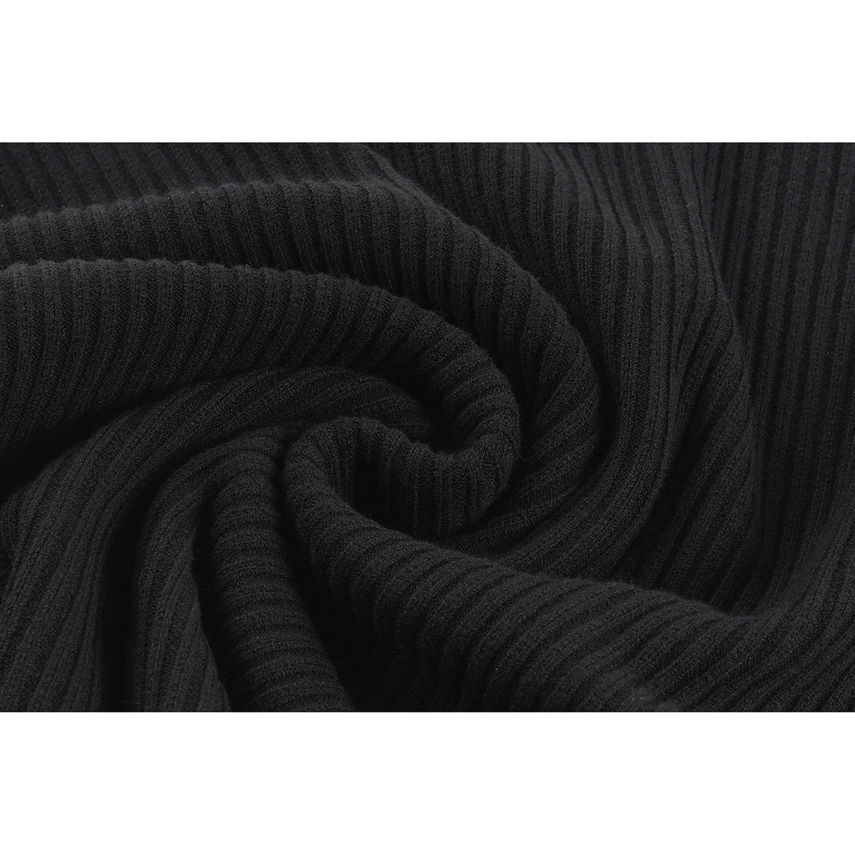 Close-up of the black sweater's ribbed knit texture, loosely folded to show its ridges.