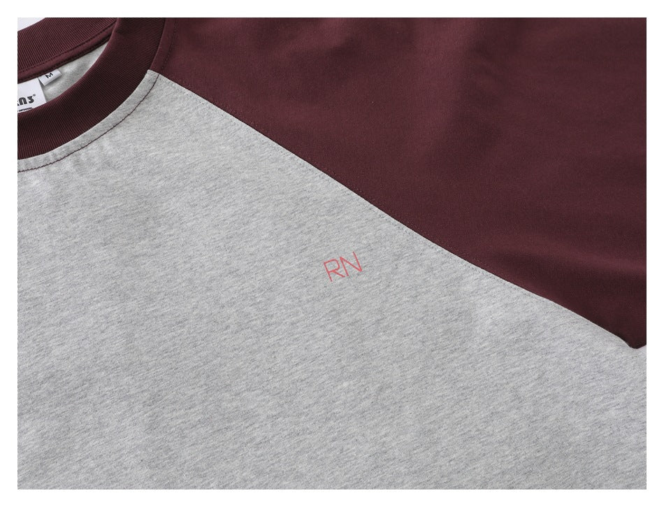 Close-up of the gray shirt front and burgundy raglan sleeve seam, with small red “RN” lettering.