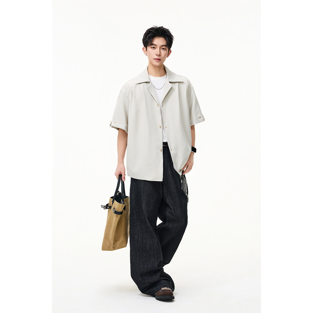 Model wearing an oversized ivory short-sleeve button-up shirt with a wide collar and rolled cuffs.