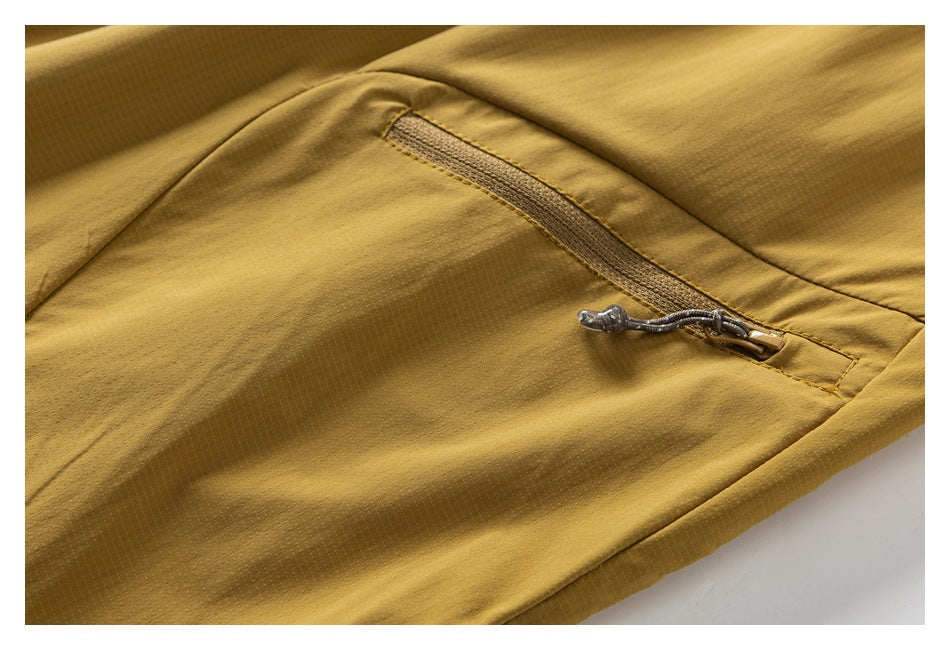 Close-up of a slanted zip pocket on mustard pants.